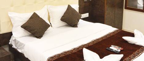A hotel room with a large bed, a wardrobe, and a mirror.