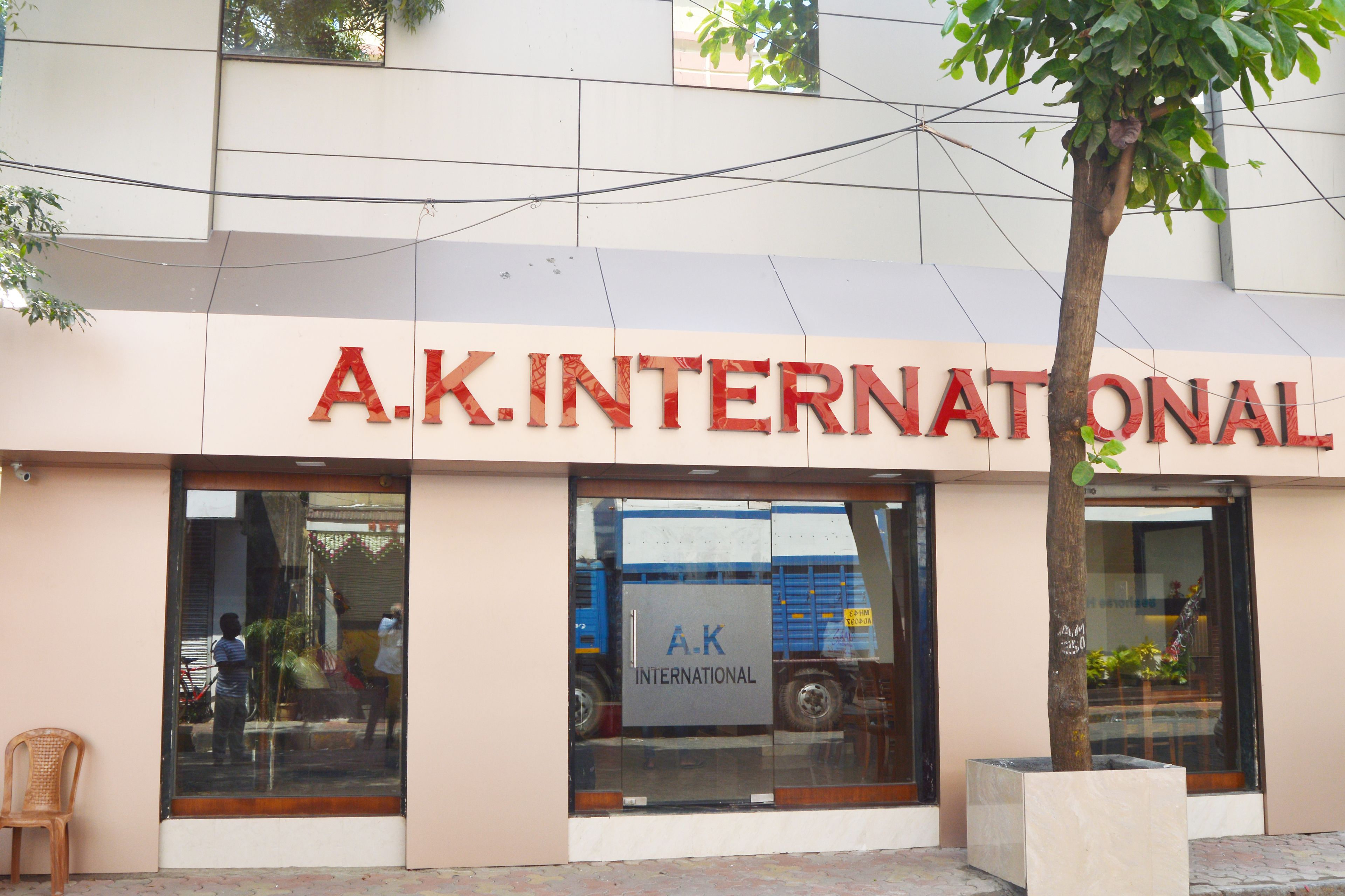 The exterior of A.K. International building with large glass windows and a signboard.