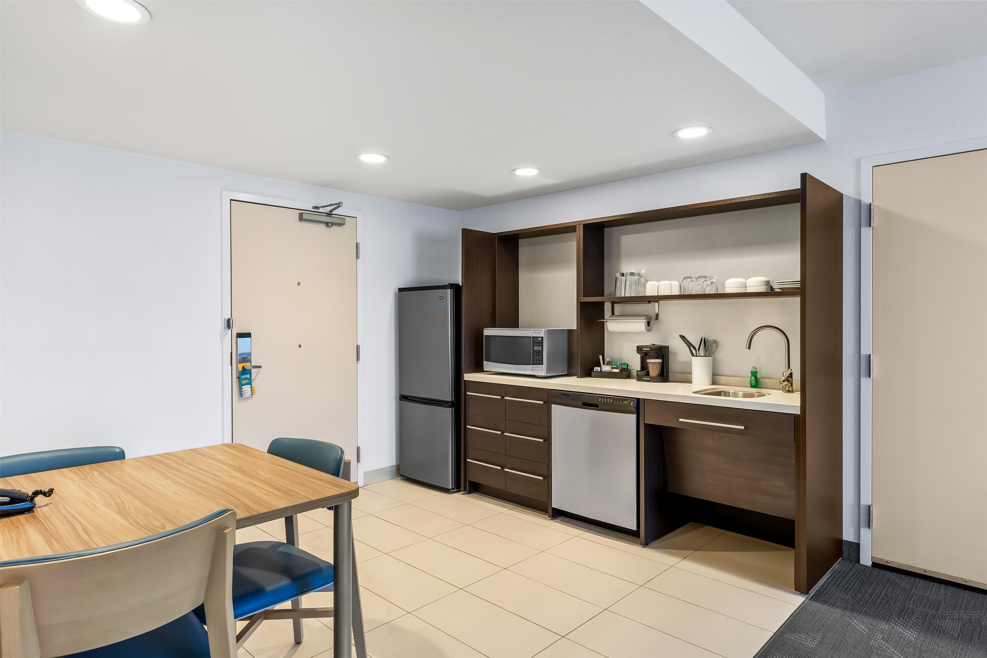 A compact kitchen with a microwave, refrigerator, and built-in sink.