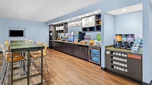 A modern cafe with a long counter, seating area, and a coffee machine.