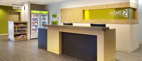 A reception area with a reception desk, a vending machine, and a self-service kiosk.