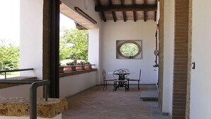 Un couloir doté d’un sol carrelé, une fenêtre offrant une vue circulaire et une table avec des chaises.