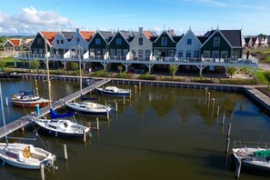 Traditional Dutch houses line the marina, offering mooring docks for boats.