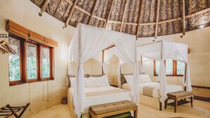 A room with two beds, each with a canopy, a bench, and a small table. - One Santuario Natural (Dibulla)
