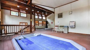 Ein Poolbereich mit Holzterrasse, einer Treppe und einer Sitzgruppe mit Tisch und Stühlen.