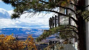 Ein Gebäude mit einer Treppe, die zu einem Balkon führt, von dem aus ein Tal mit Bergen in der Ferne zu sehen ist.