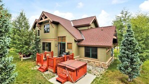 A two-story house with a deck and a hot tub. - Highland Green 91 Town House (Breckenridge)