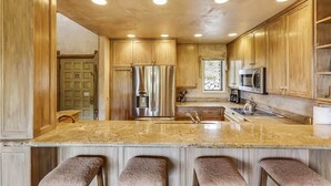 A kitchen with wooden cabinets, stainless steel appliances, and a granite countertop. - Storm Meadows Townhouse 17 Town House (Steamboat Springs)