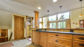 A spacious kitchen with wooden cabinets, a large island, and a window providing natural light.