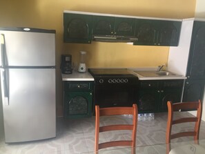 Een magnetron, een kookplaat, kookgerei, borden en bestek