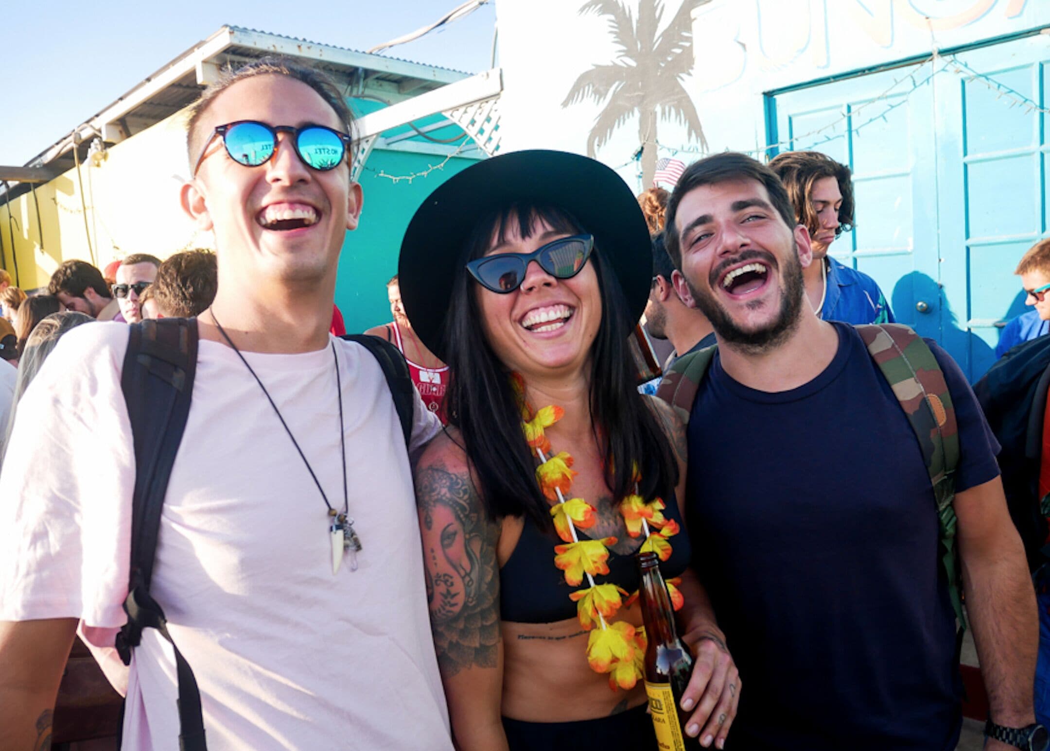 A group of people at an outdoor event with a blue building in the background.