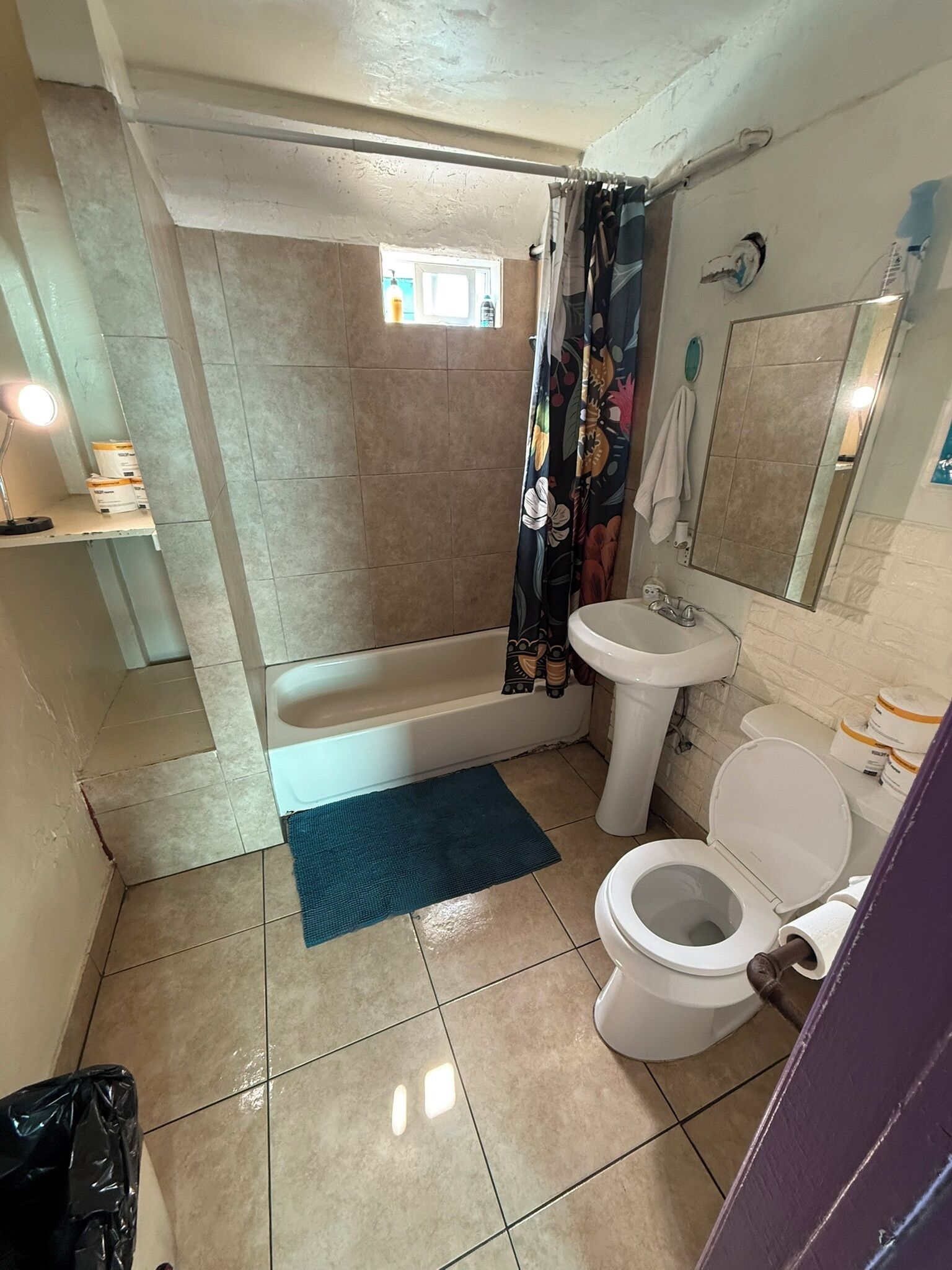 A bathroom with a bathtub, toilet, sink, and shower curtain.