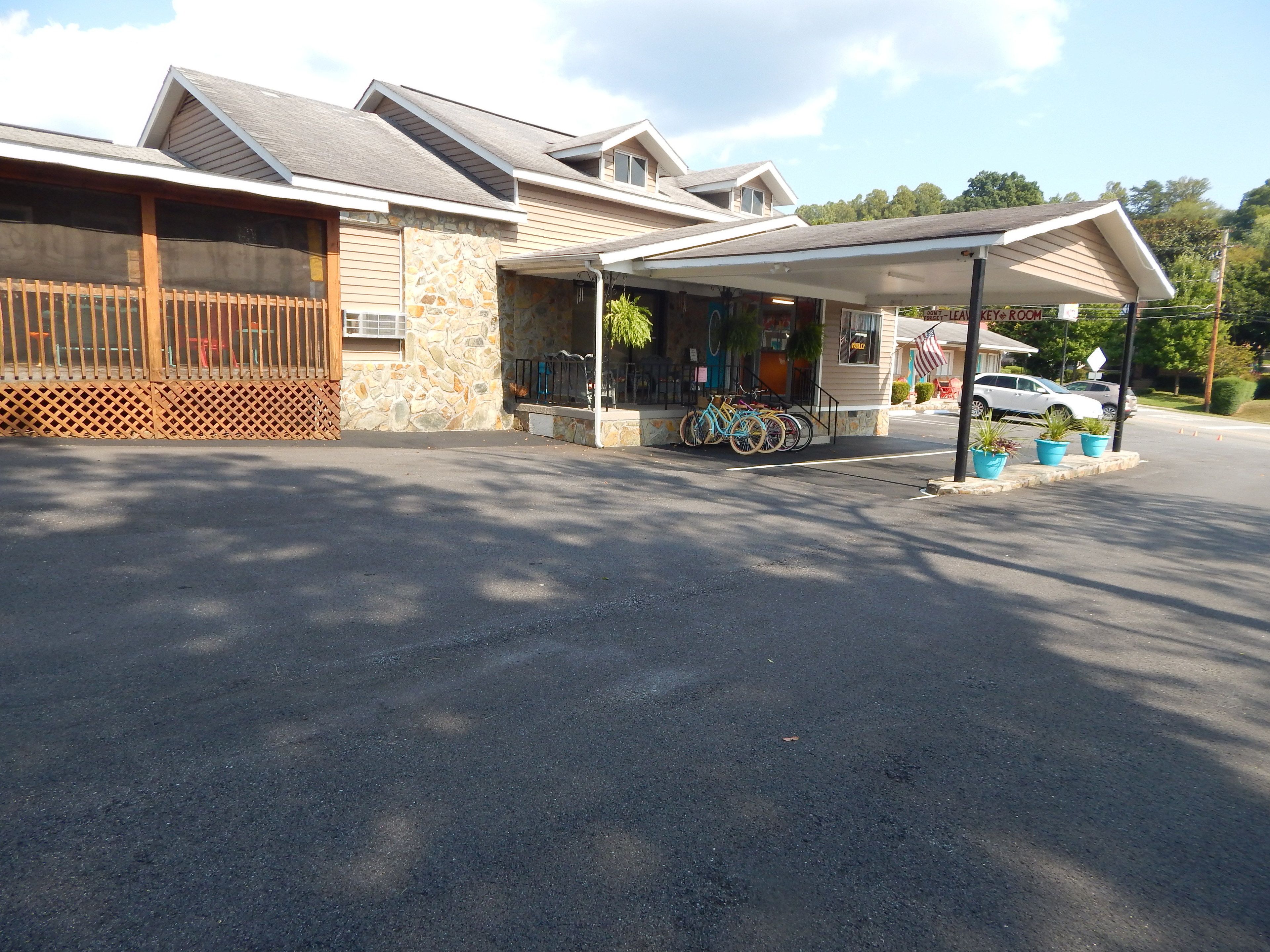 A two-story building with a stone facade and a covered parking area.