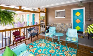 Un espacio al aire libre cubierto con muebles de madera y un colorido tapete estampado.