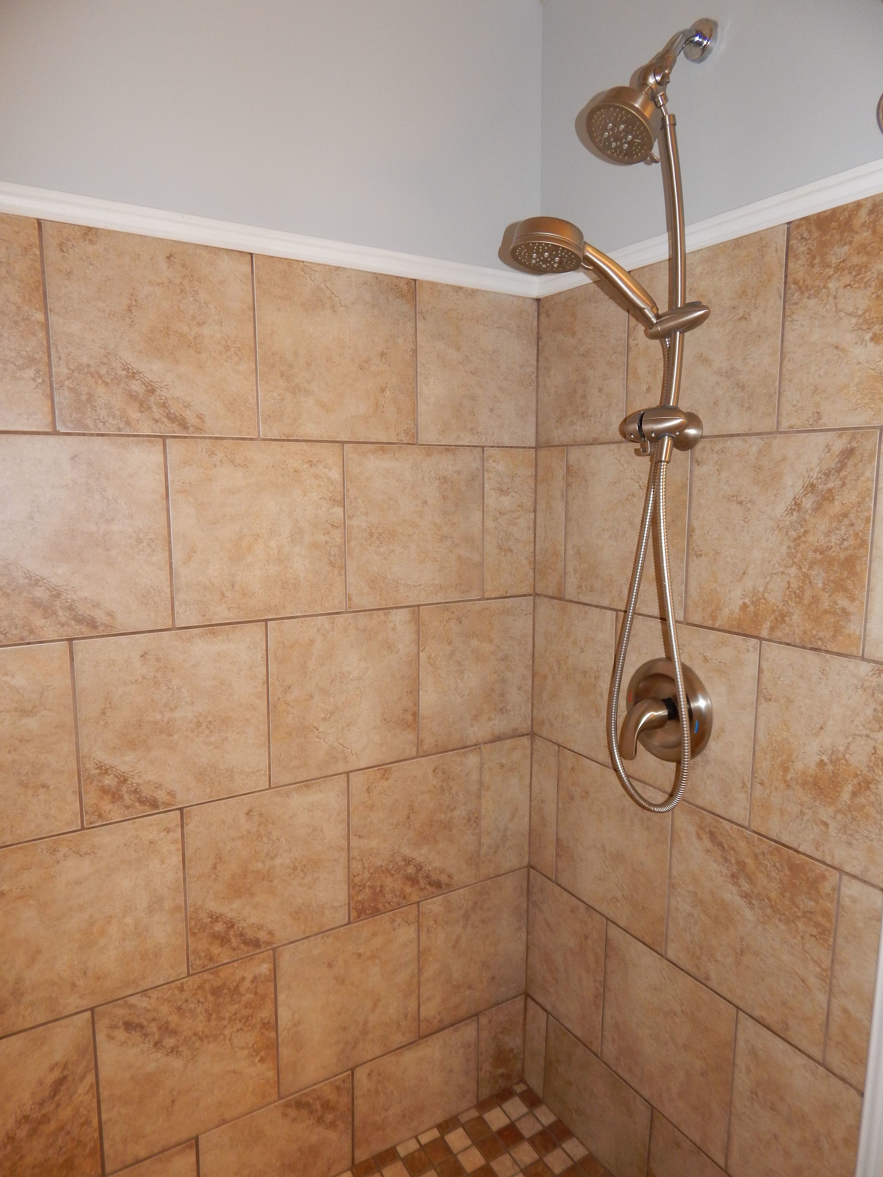 A shower with a handheld showerhead and a wall-mounted faucet.