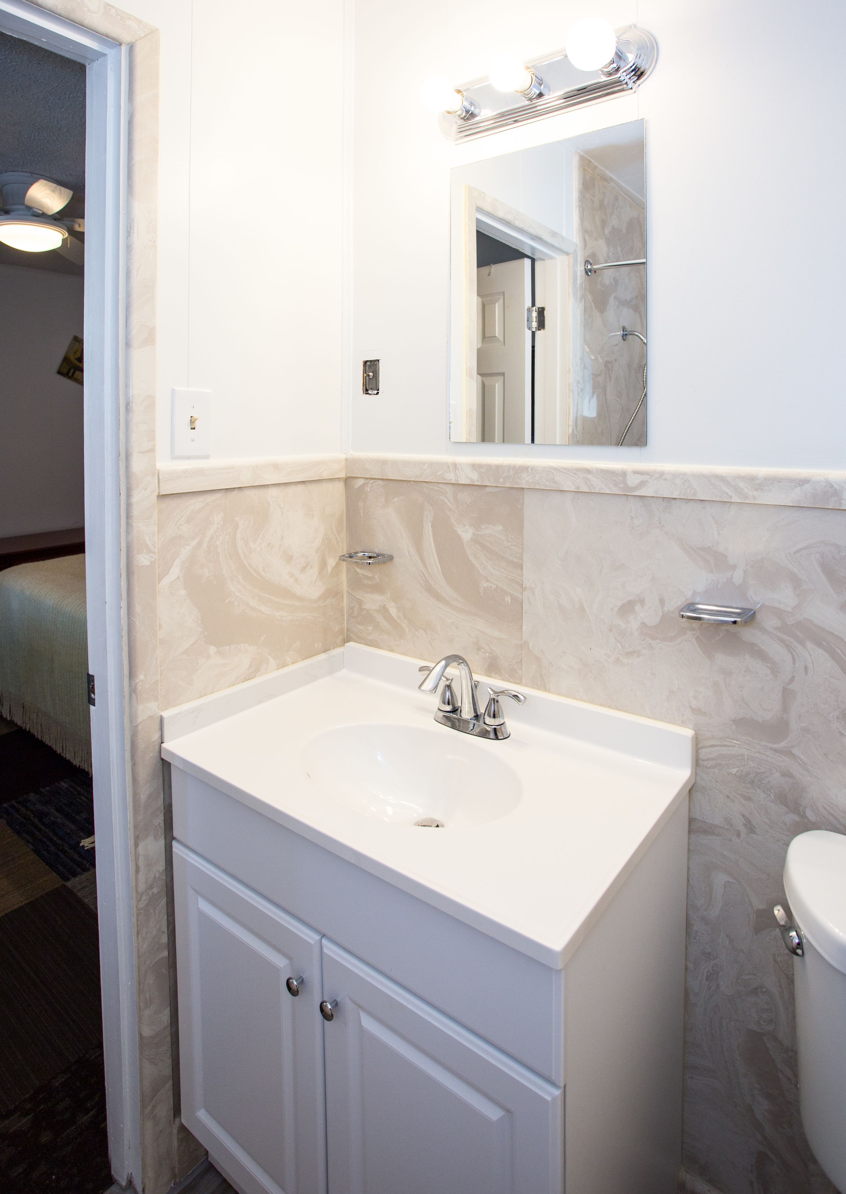 A bathroom with a white sink, a mirror, and a shower.