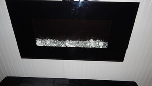 A black-framed wall-mounted TV with a decorative border of small, reflective elements. - Sunset Motel (Murphy)