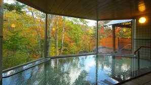 Ein Hallenbad mit Blick auf Herbstbäume.
