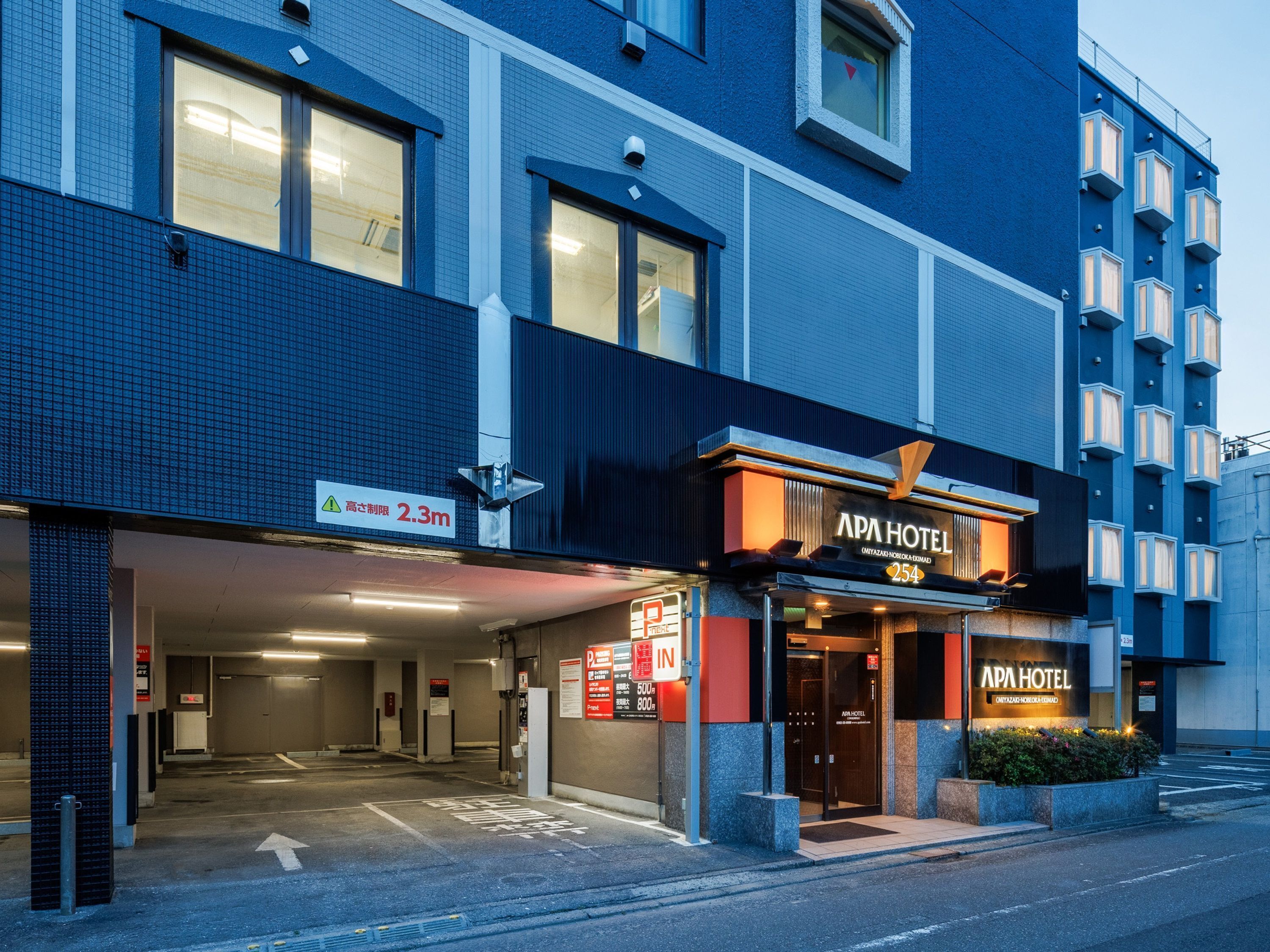 Un hôtel moderne doté d’une entrée imposante, d’une signalétique claire et d’une façade bien éclairée.