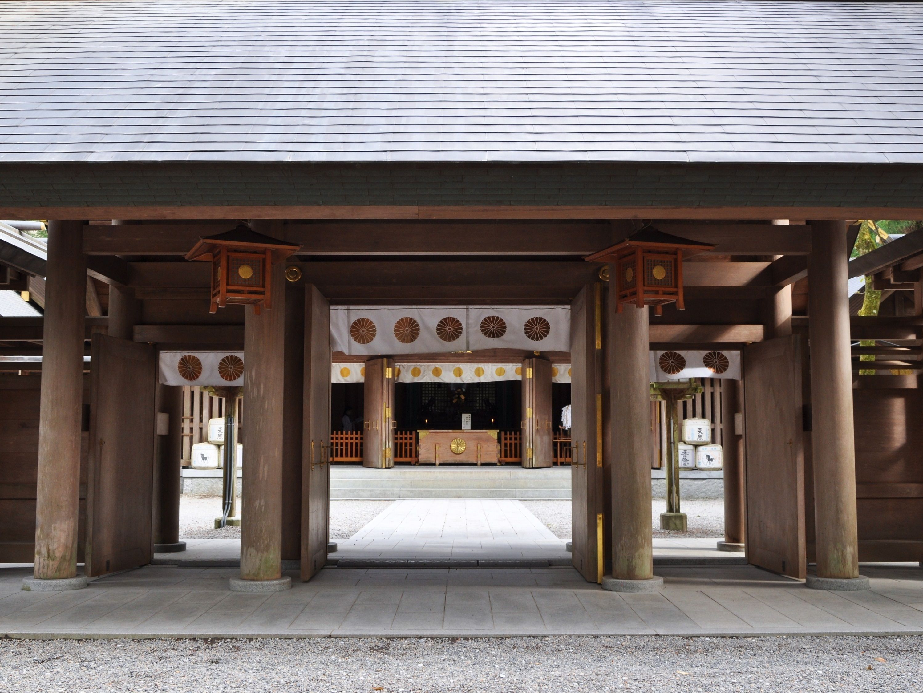 Un edificio japonés tradicional con un porche cubierto, columnas de madera y suelo de baldosas.