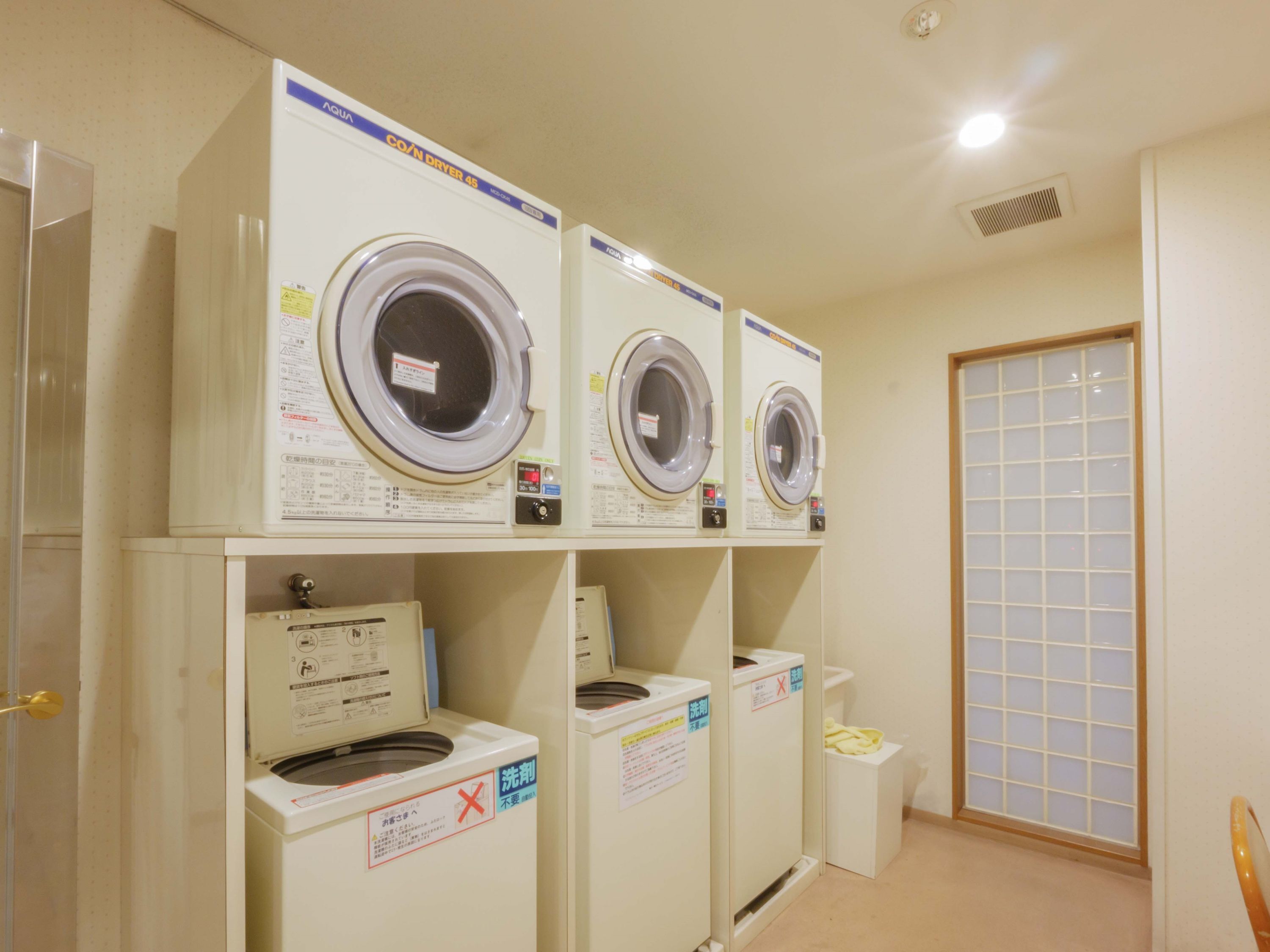 A laundry room with three stacked washing machines and a dryer.