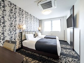 Una habitación de hotel con dos camas, un televisor, un ventilador de techo y un ventanal grande.
