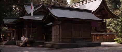 A traditional wooden building with a sloped roof and a flagpole.