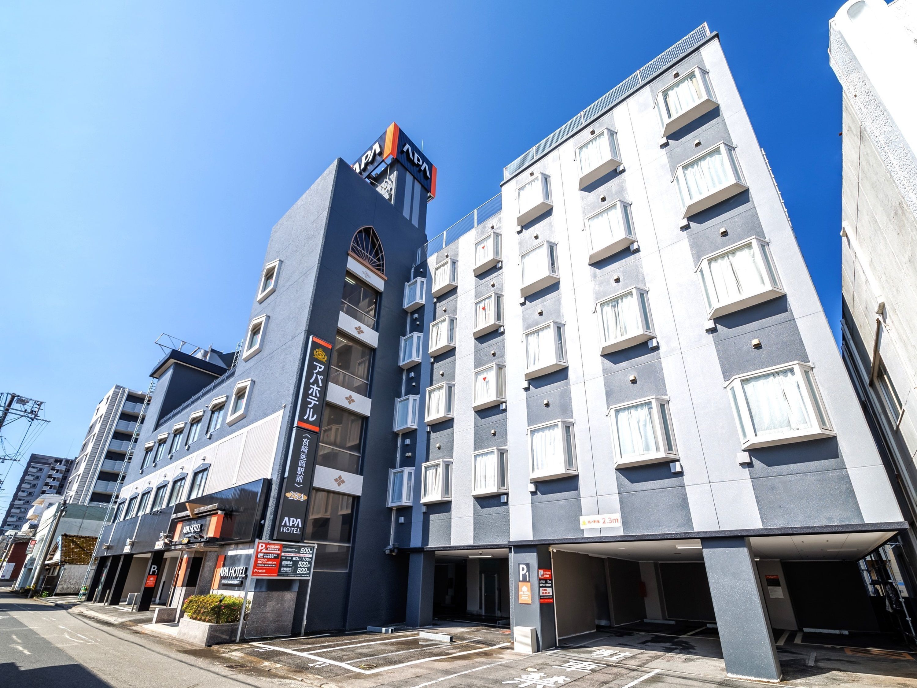 A multi-story hotel with a modern design, featuring a prominent sign for the SPA HOTEL and a parking area with marked spaces.