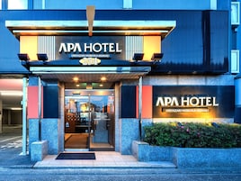 Exterior del hotel APA, con fachada moderna, puertas de entrada y el número de la dirección visible.