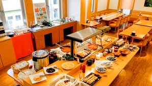 A buffet setup with various food items and a seating area with tables and chairs. - APA Hotel Miyazaki Nobeoka Ekimae (Nobeoka)