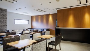 A modern hotel lobby with a long reception desk, multiple seating areas, and a large window providing natural light. - APA Hotel Miyazaki Nobeoka Chuo (Nobeoka)