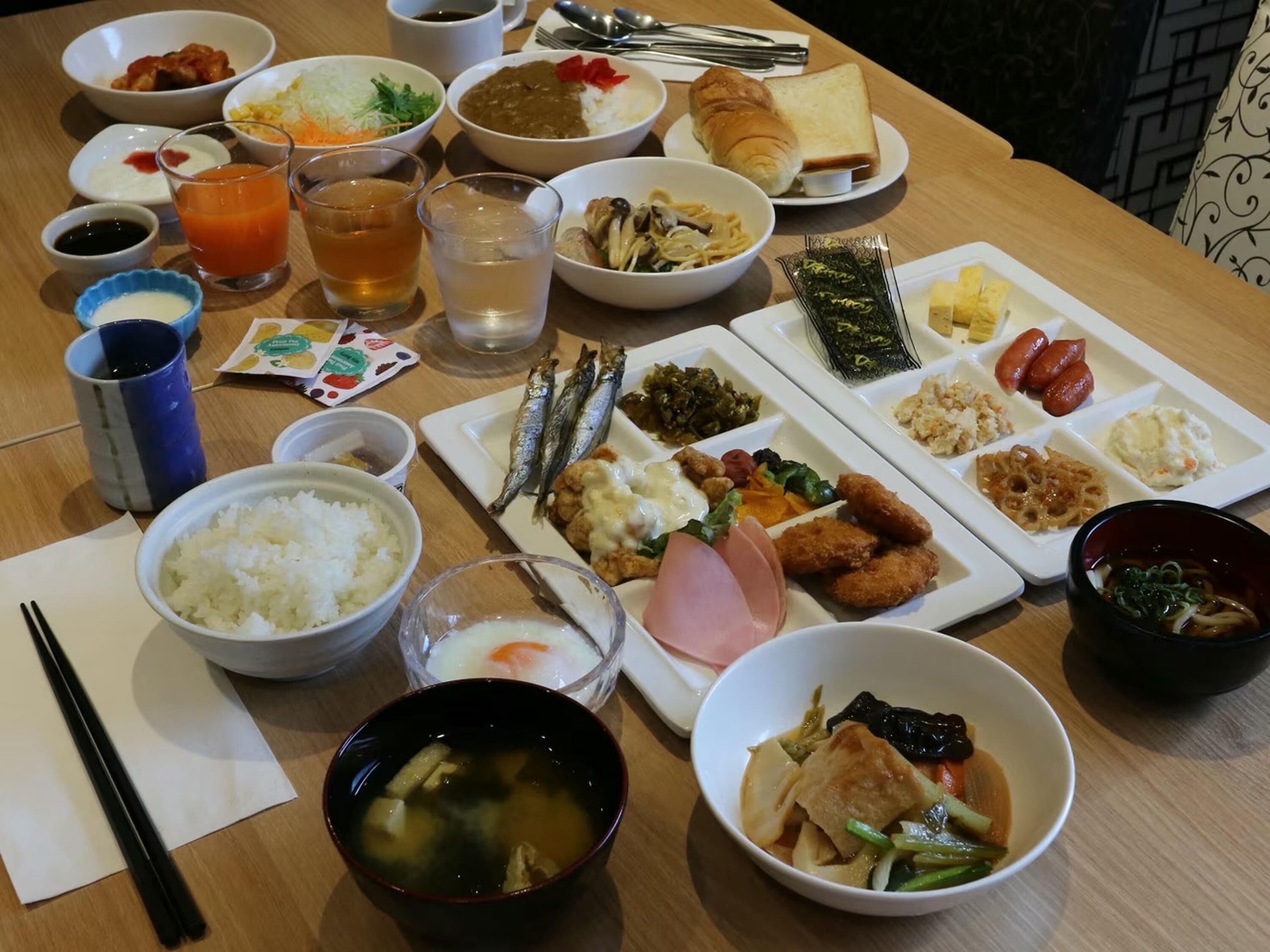 Diversos platos, como arroz, sopa y mariscos, dispuestos sobre una mesa de madera.