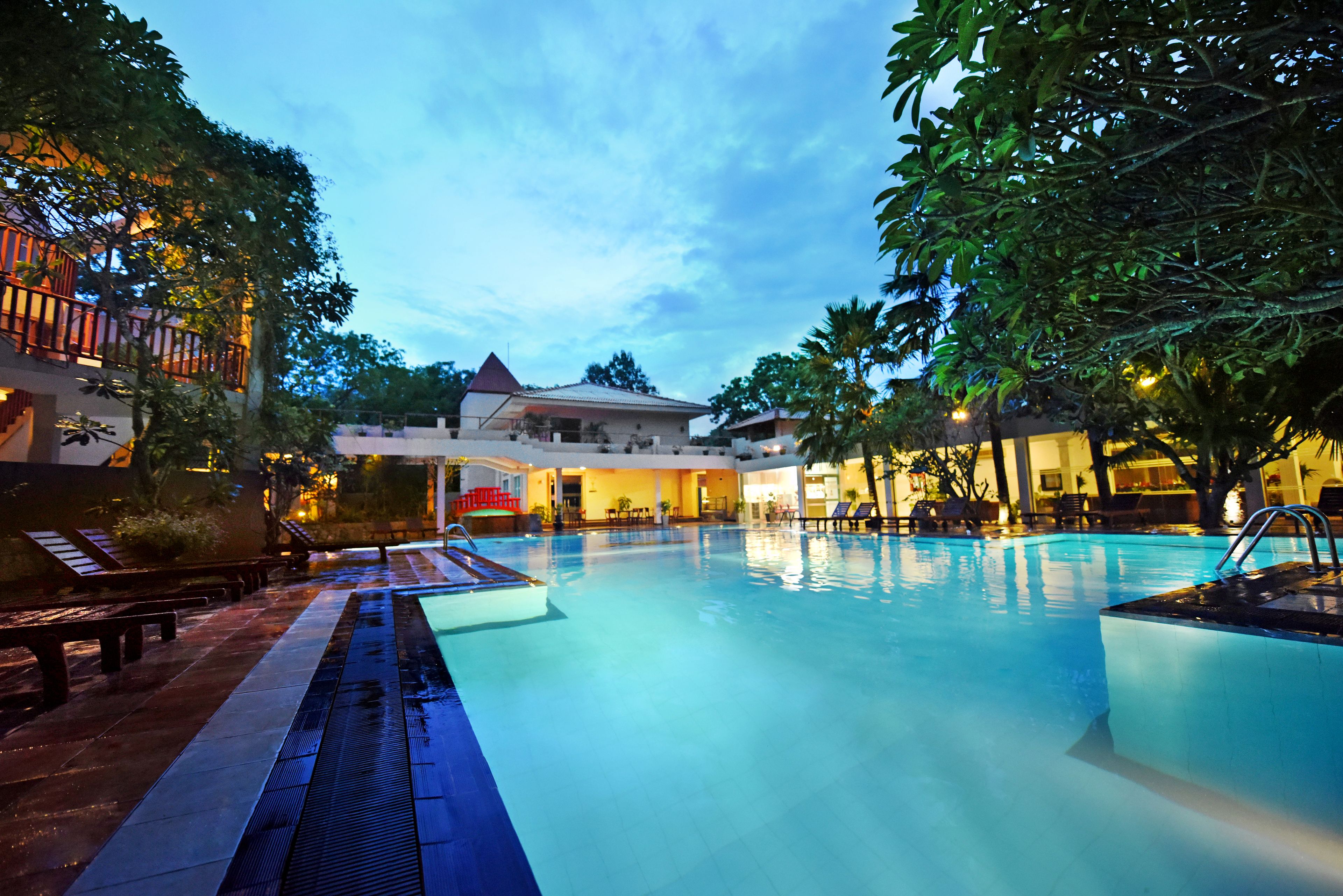 A swimming pool with lounge chairs and a building in the background.