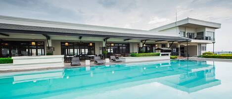 Una piscina al aire libre, tumbonas