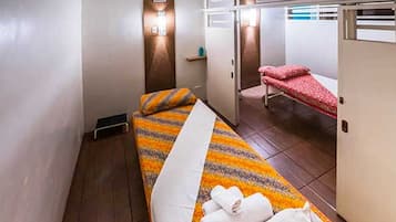 Cozy retreat with a single bed, bedside table, and wall-mounted light.