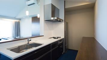 Una cocina moderna con un lavamanos de acero inoxidable, horno empotrado, estufa a gas y refrigerador.