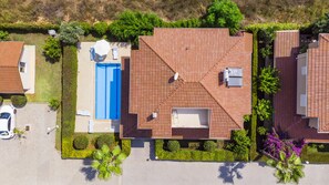 An aerial view of a residential area with a house featuring a swimming pool, a covered patio, and a solar water heater. - Paradise Town Villa Hazel (Serik)