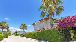 A residential street with houses, palm trees, and a hedge. - Paradise Town Villa Hazel (Serik)