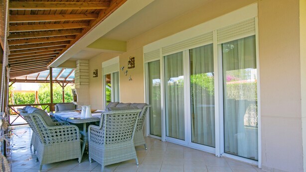 A covered patio area with wicker furniture, a table, and a chair. - Paradise Town Villa Hazel (Serik)