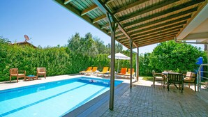 A swimming pool with lounge chairs and a covered patio area. - Paradise Town Villa Hazel (Serik)