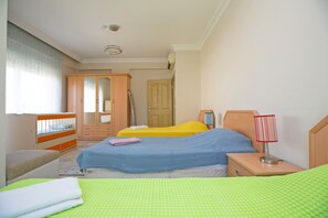 A bedroom with two beds, a wardrobe, a bedside table with a lamp, and a window with curtains. - Paradise Town Villa Hazel (Serik)