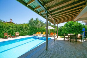 A swimming pool with lounge chairs and a covered patio area. - Paradise Town Villa Hazel (Serik)