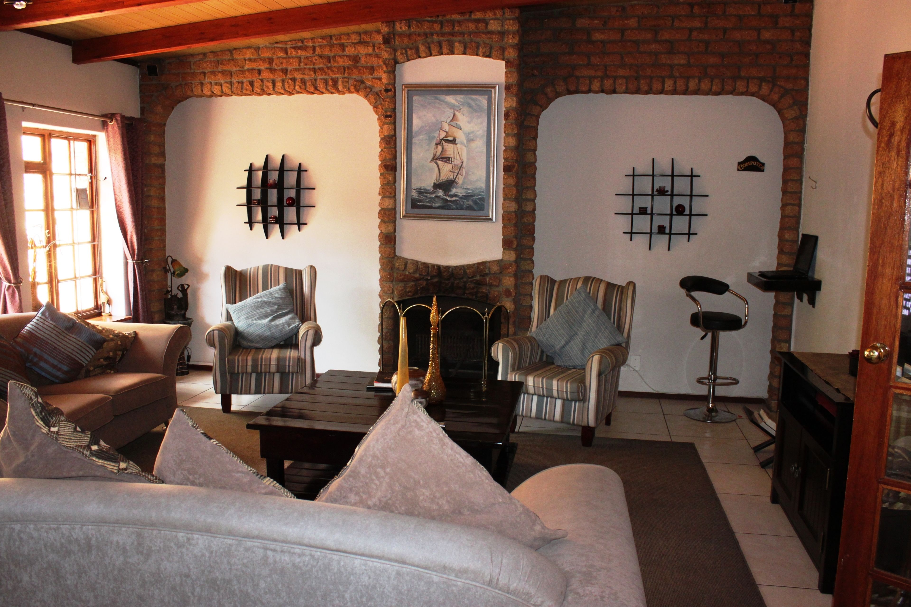 Una sala de estar acogedora con chimenea, sillones a rayas, un sofá y una mesa de centro.