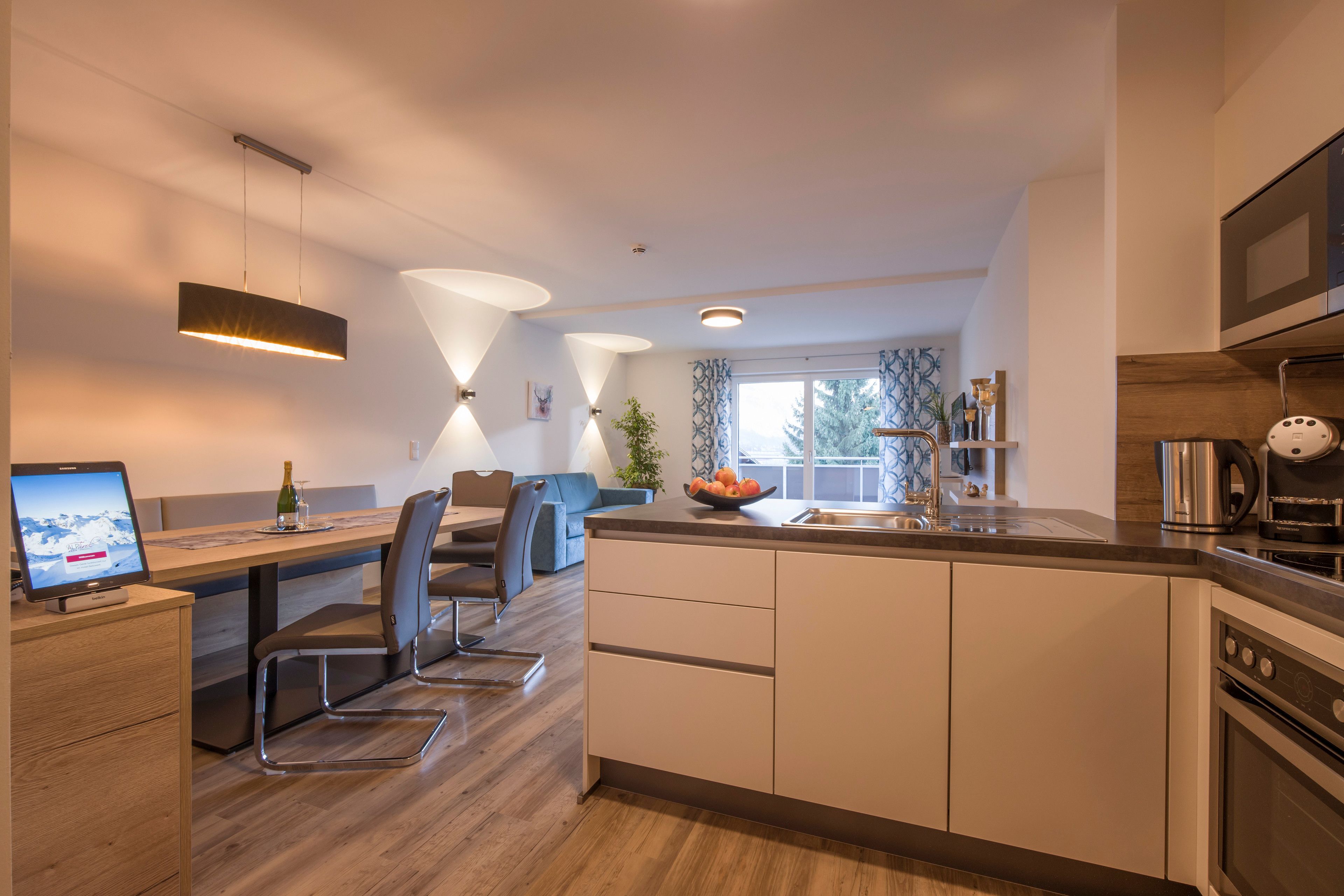 Una cucina moderna con isola centrale, elettrodomestici integrati e zona pranzo con vista sull'esterno.