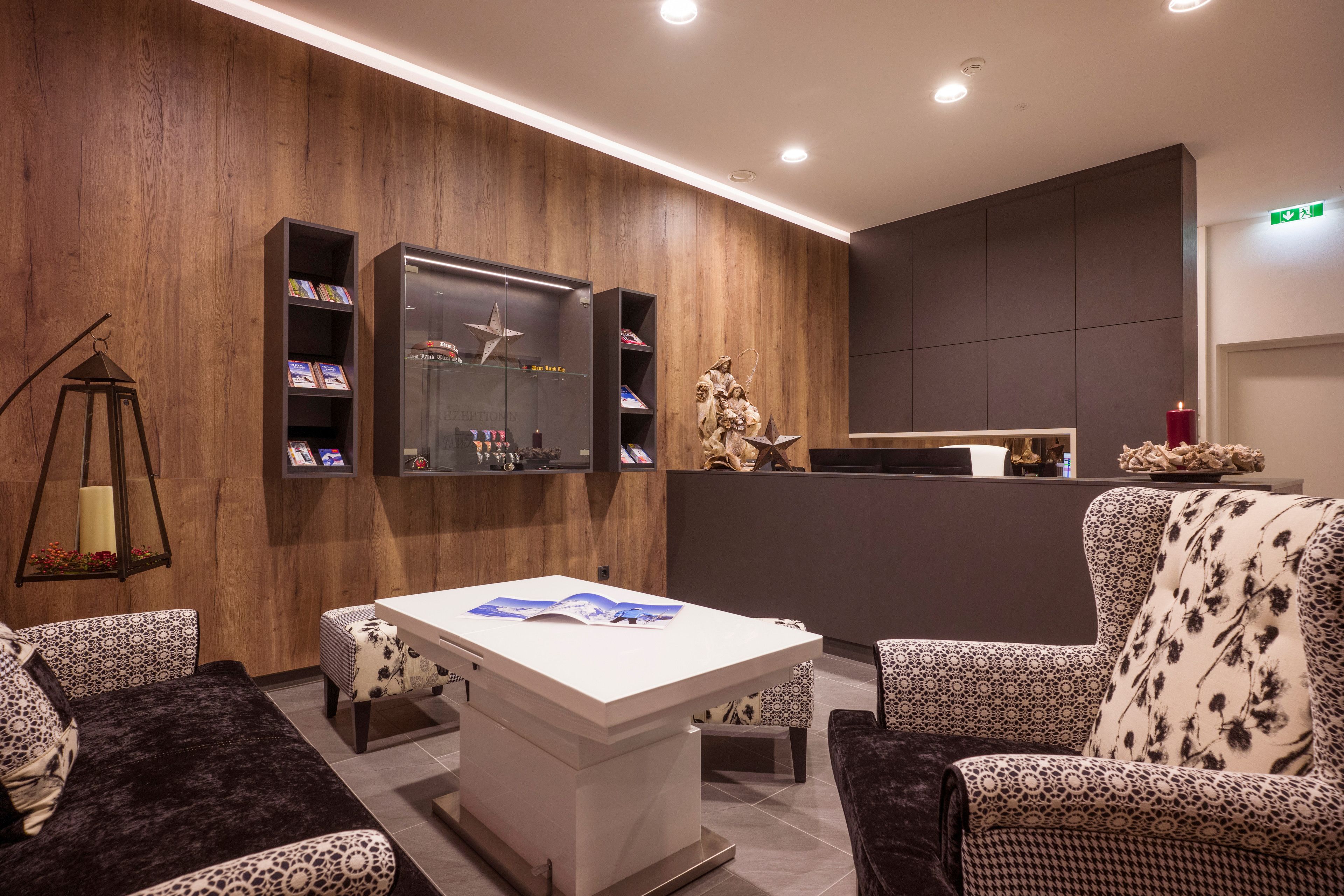 A modern lobby with a wooden wall, a reception desk, and patterned furniture.