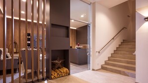 Un interno moderno con una scala, una zona salotto con arredi decorati e una cucina a vista.