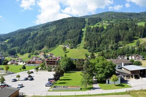 A residential area with houses, a parking lot, and a hill with dense forest.