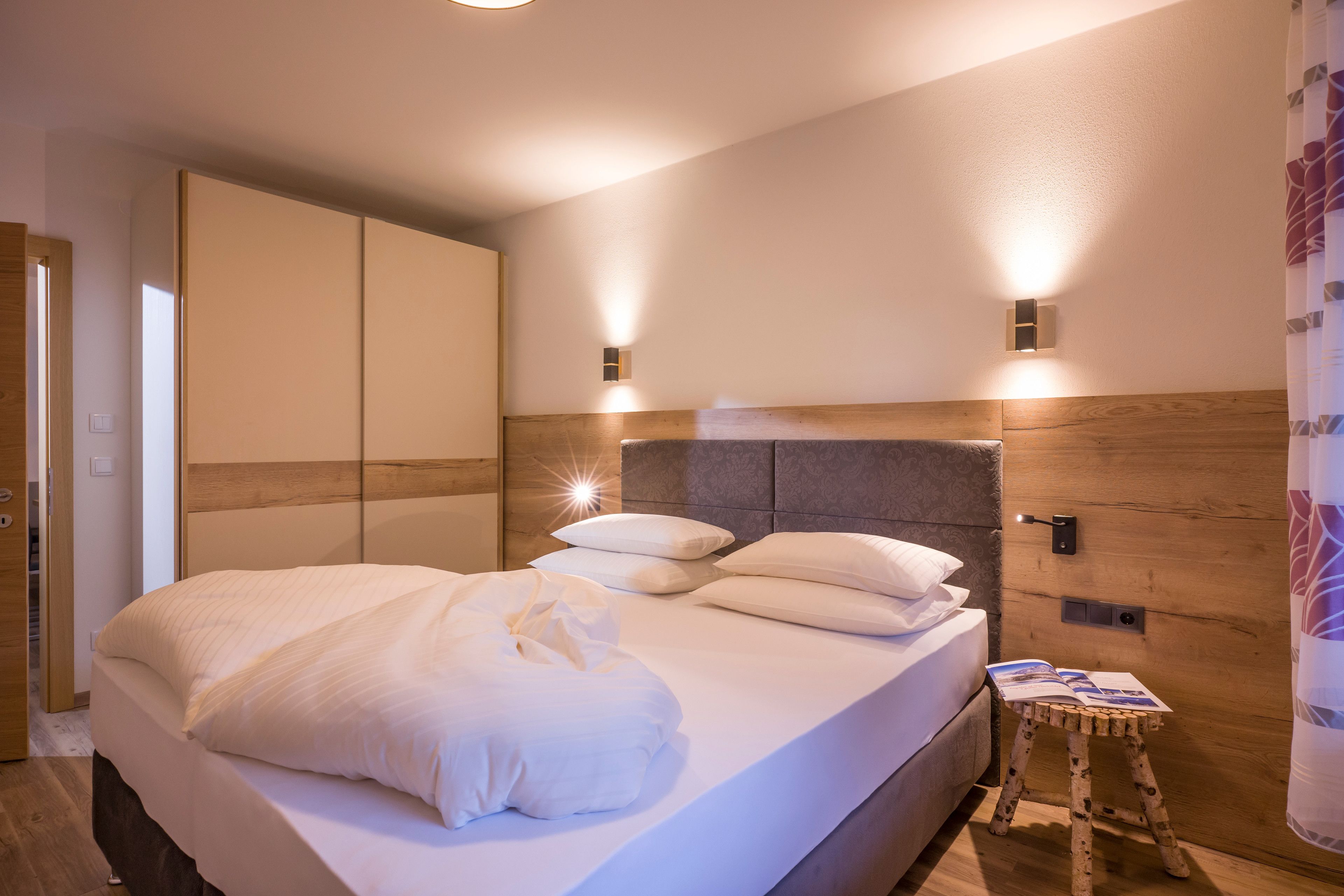 Ein Schlafzimmer mit einem Bett, einem Nachttisch und einem hölzernen Kopfteil.