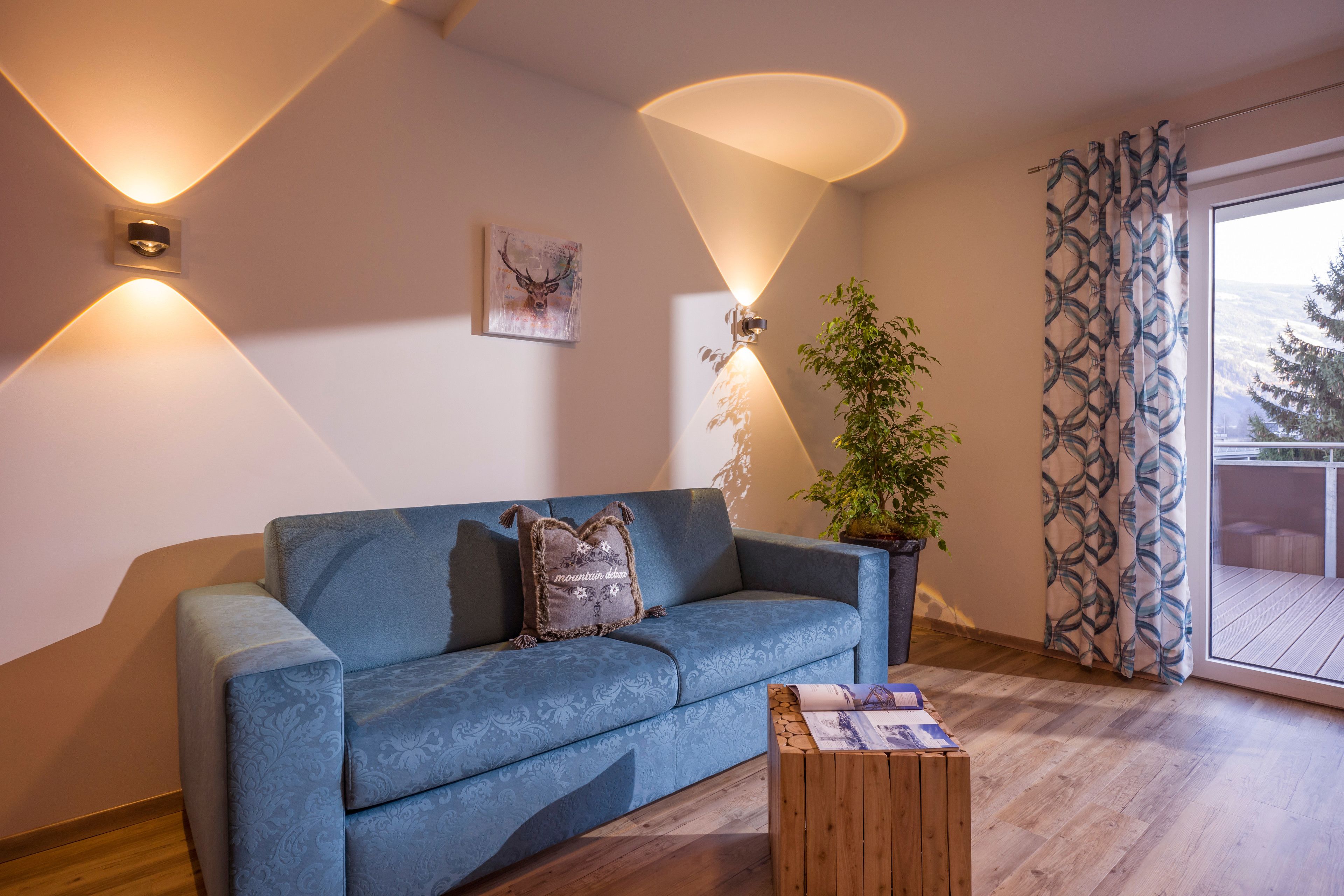Un salon moderne avec un canapé bleu, une table basse en bois et une plante en pot.