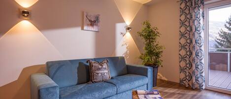 Un salon moderne avec un canapé bleu, une table basse en bois et une plante en pot.